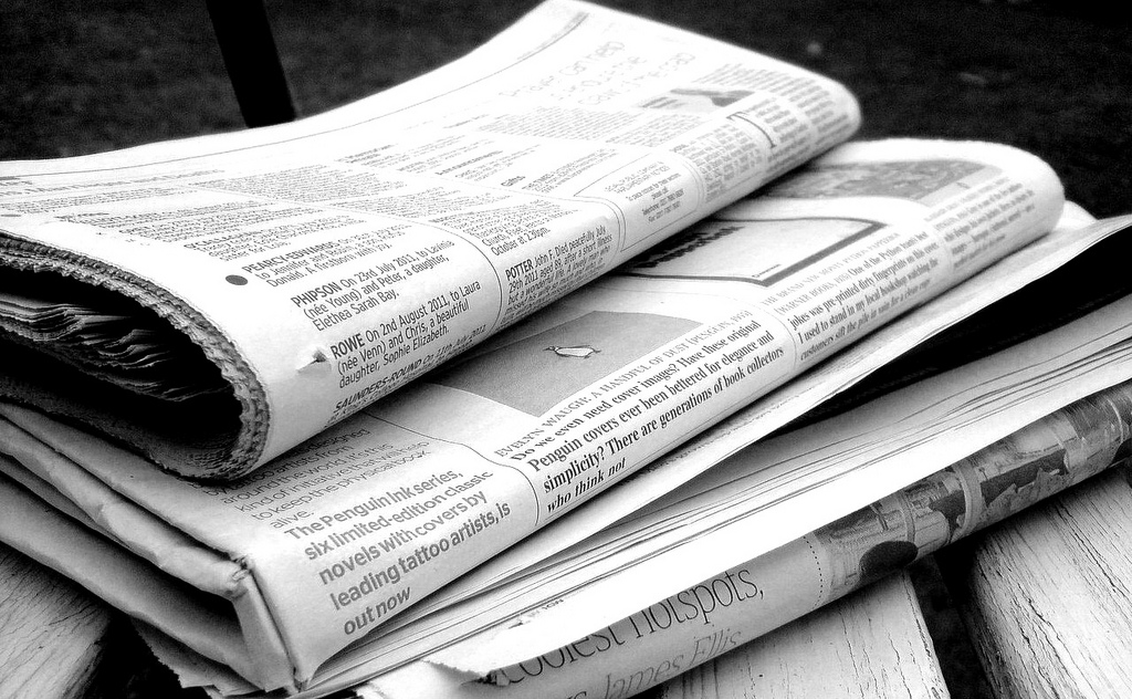 “Newspapers B&W” by Jon S is licensed under CC BY 2.